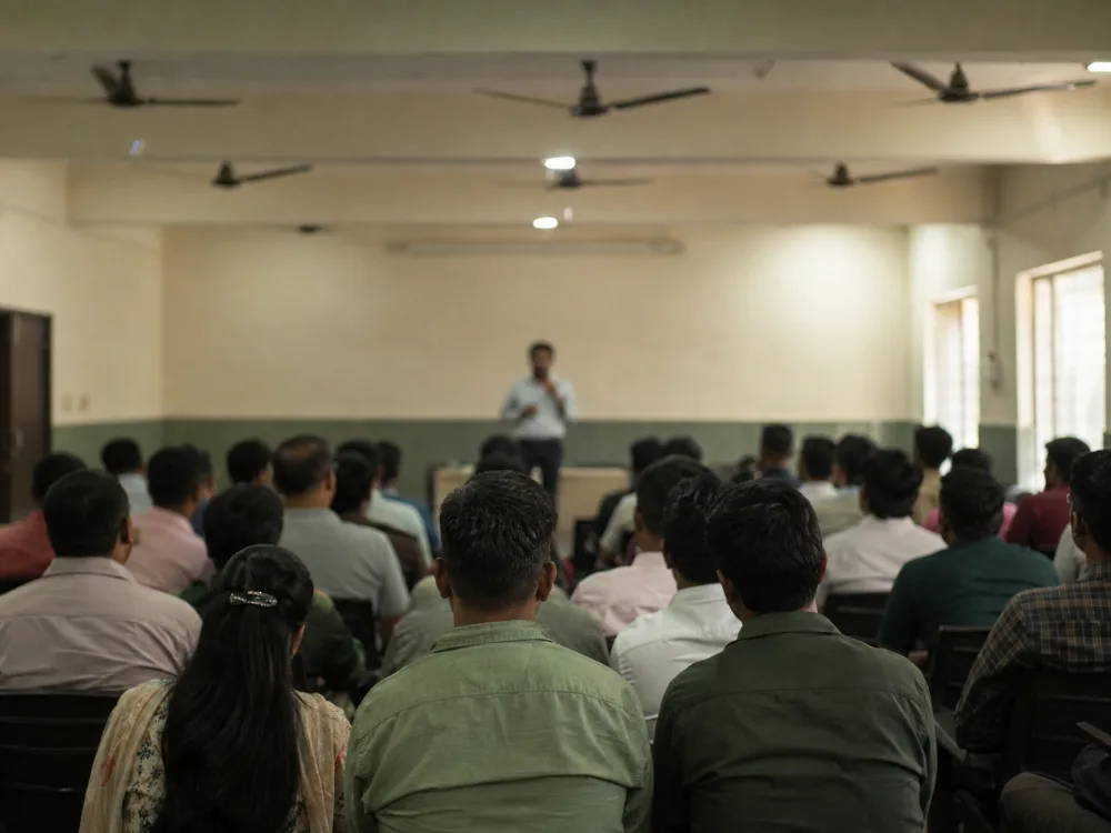 A training session in progress in a plain hall, seen from the back of the room